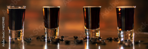 four alcohol coffee shot and coffee beans on the wooden table panorama photo