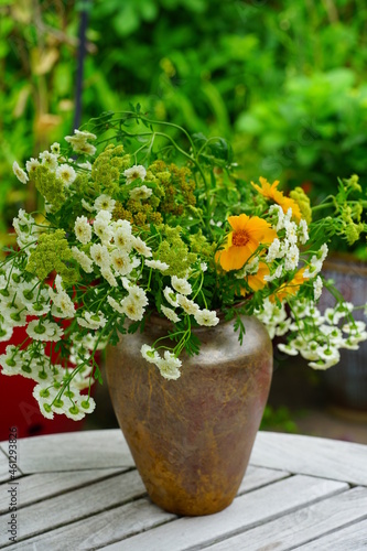 Fototapeta Naklejka Na Ścianę i Meble -  Yellow and white floral arrangement made with feverfew, coreopsis and lovage flowers