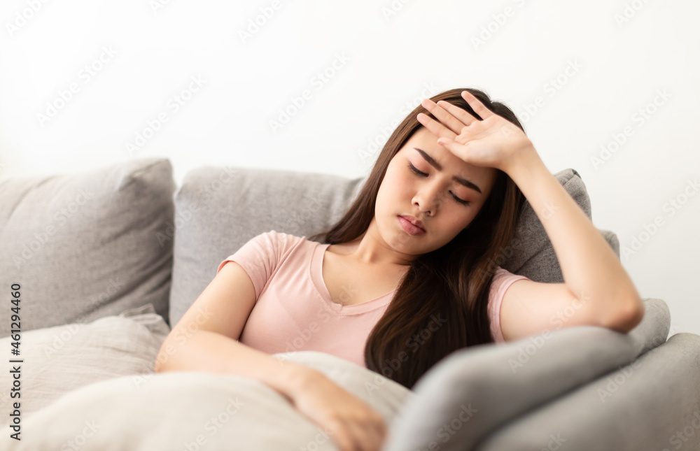 Asian young woman holding her hands on the forehead and have a headache on the sofa. Asian young woman holding her hands on the forehead and have a headache on the sofa.