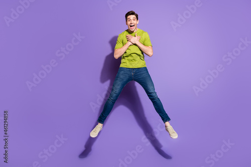 Full length body size view of attractive cheerful impressed guy jumping isolated over vivid violet purple color background