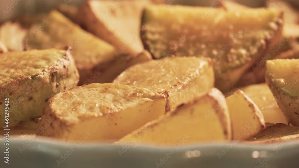 Sliced potatoes are baked on a platter in a home kitchen oven, time lapse Sliced potatoes are baked on a platter in a home kitchen oven, time lapse