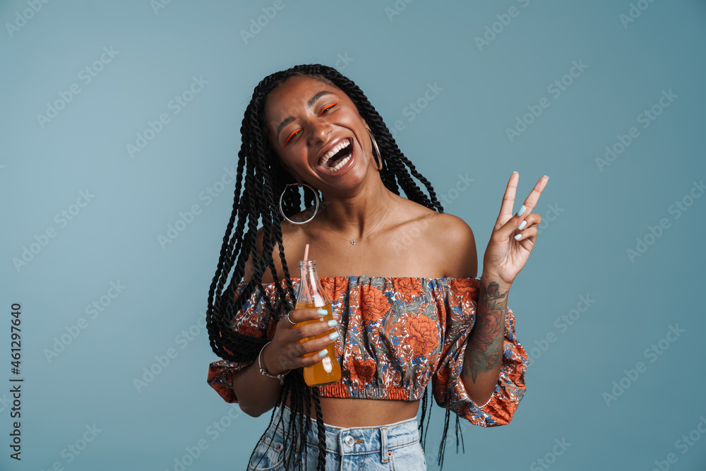 Young black woman drinking soda while showing peace gesture
