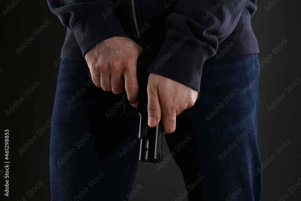 Man reloading gun on black background, closeup Man reloading gun on black background, closeup