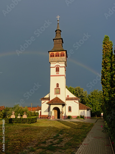  Sunlit Assumption church of against a dark sky with rainbow in Orastie, Romania  photo