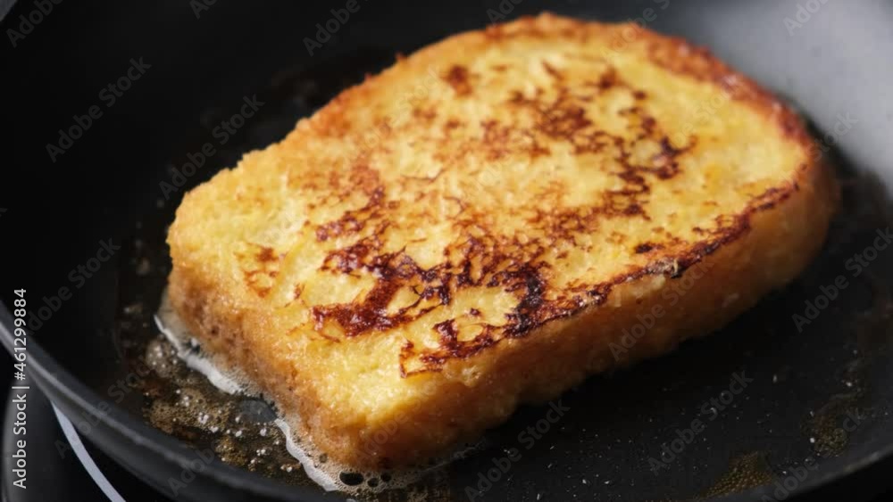 French toast frying on black pan in butter, closeup view French toast frying on black pan in butter, closeup view