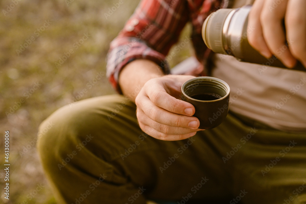 White man drinking tea during camping on summer day White man drinking tea during camping on summer day