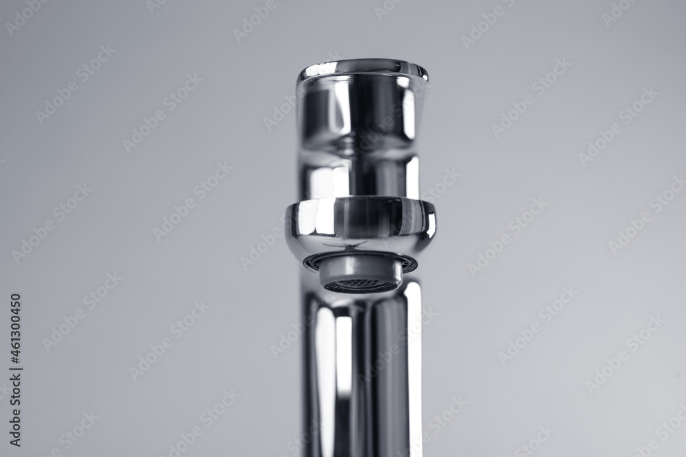Single handle water tap on grey background, closeup Single handle water tap on grey background, closeup