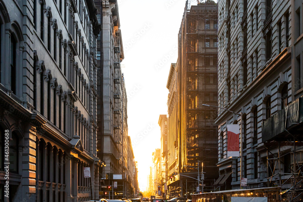 The light of summer sunset shines between the buildings on 19th Street in Manhattan, New York City
