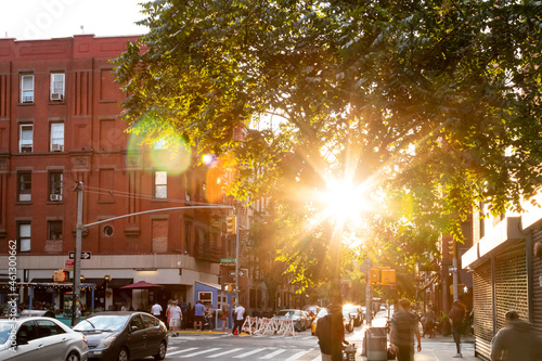 Sunlight shining on the busy intersection on Clinton Street in the Lower East Side neighborhood of New York City