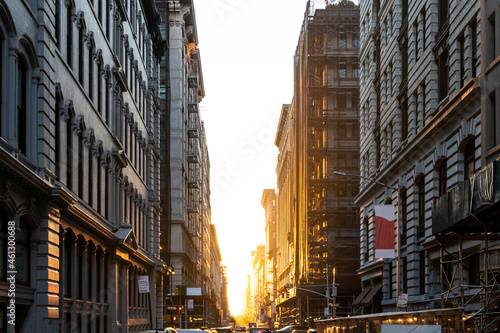 The light of summer sunset shines between the buildings on 19th Street in Manhattan, New York City © deberarr