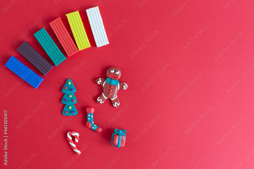 plasticine homemade figures, symbols of the new year and Christmas pieces of plasticine on a red background