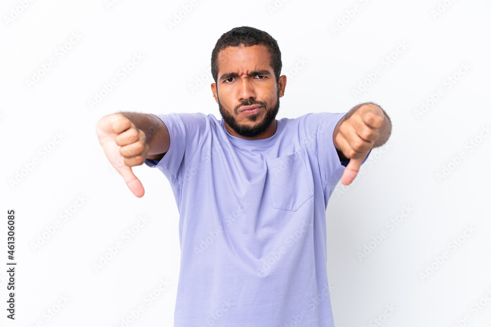 Young Ecuadorian man isolated on white background showing thumb down with two hands Young Ecuadorian man isolated on white background showing thumb down with two hands
