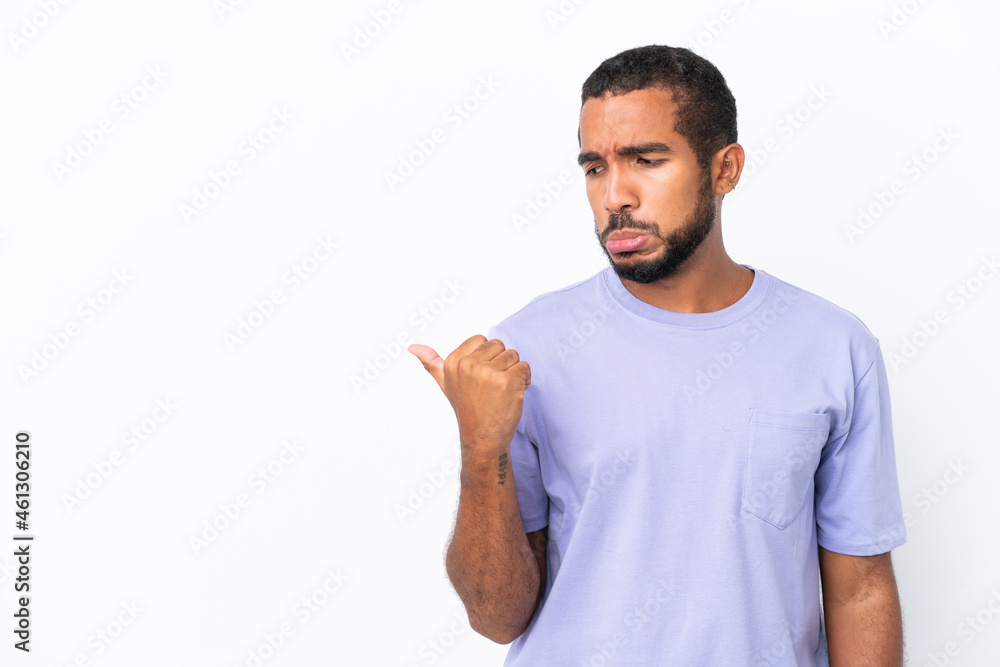 Young Ecuadorian man isolated on white background unhappy and pointing to the side Young Ecuadorian man isolated on white background unhappy and pointing to the side