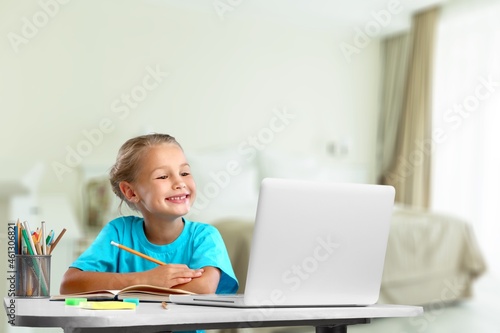 Happy cute schoolgirl drawing picture at home
