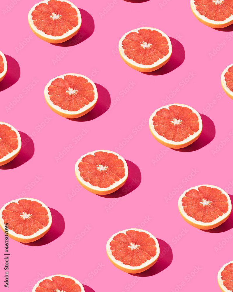 Trendy pattern made with grapefruit slice on pastel pink background. Minimal fruit concept. Trendy pattern made with grapefruit slice on pastel pink background. Minimal fruit concept.