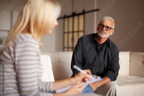 Comfortable psychotherapy. An elderly patient with a problem, session with a psychologist. The doctor listens and writes down the diagnosis.