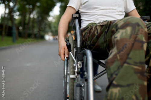 Young male person in wheelchair, view on legs