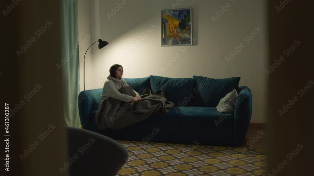 lonely woman misses the room sitting on an emerald sofa wrapped in a blanket lonely woman misses the room sitting on an emerald sofa wrapped in a blanket