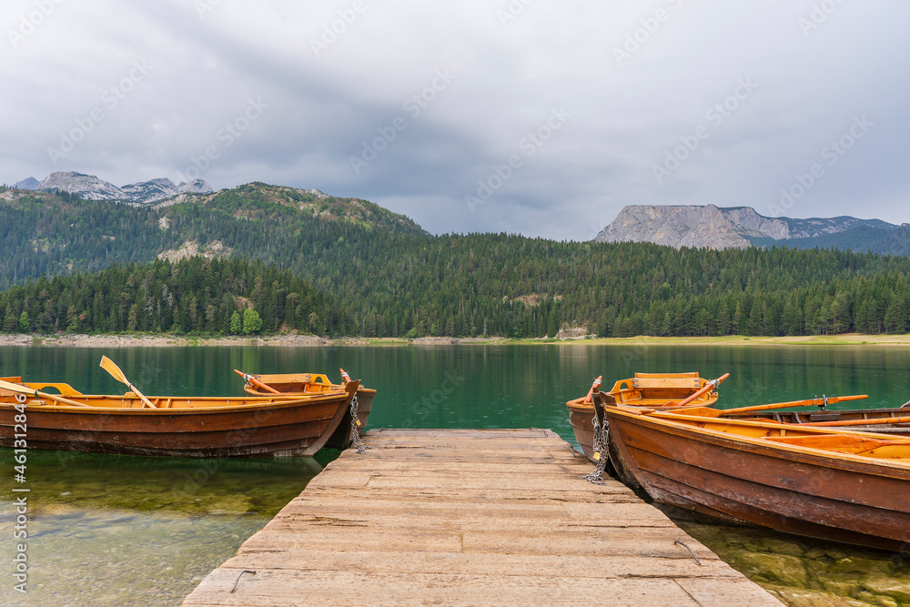 Tourist boats near wooden pier on Black lake in Montenegro, Europe