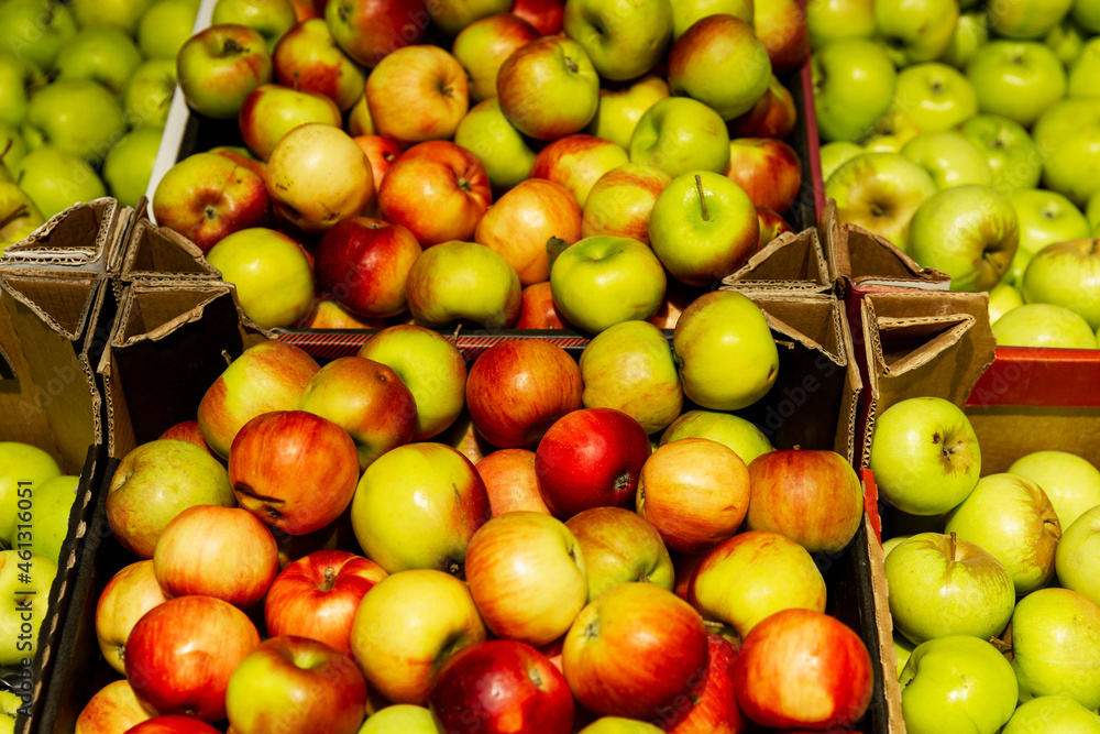 Many different apples in boxes on the market counter. Health and vitamins from nature. Many different apples in boxes on the market counter. Health and vitamins from nature.