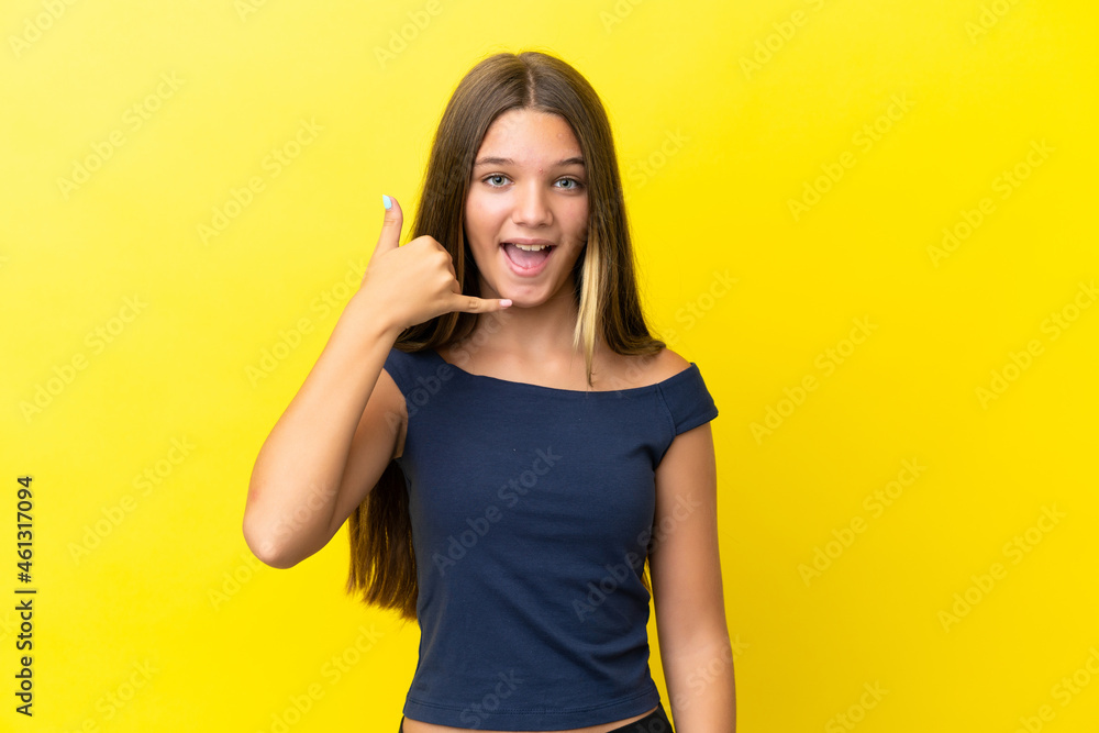 Little caucasian girl isolated on yellow background making phone gesture. Call me back sign Little caucasian girl isolated on yellow background making phone gesture. Call me back sign