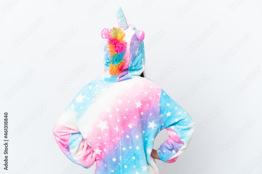 Little caucasian girl wearing unicorn pajama isolated on white background in back position