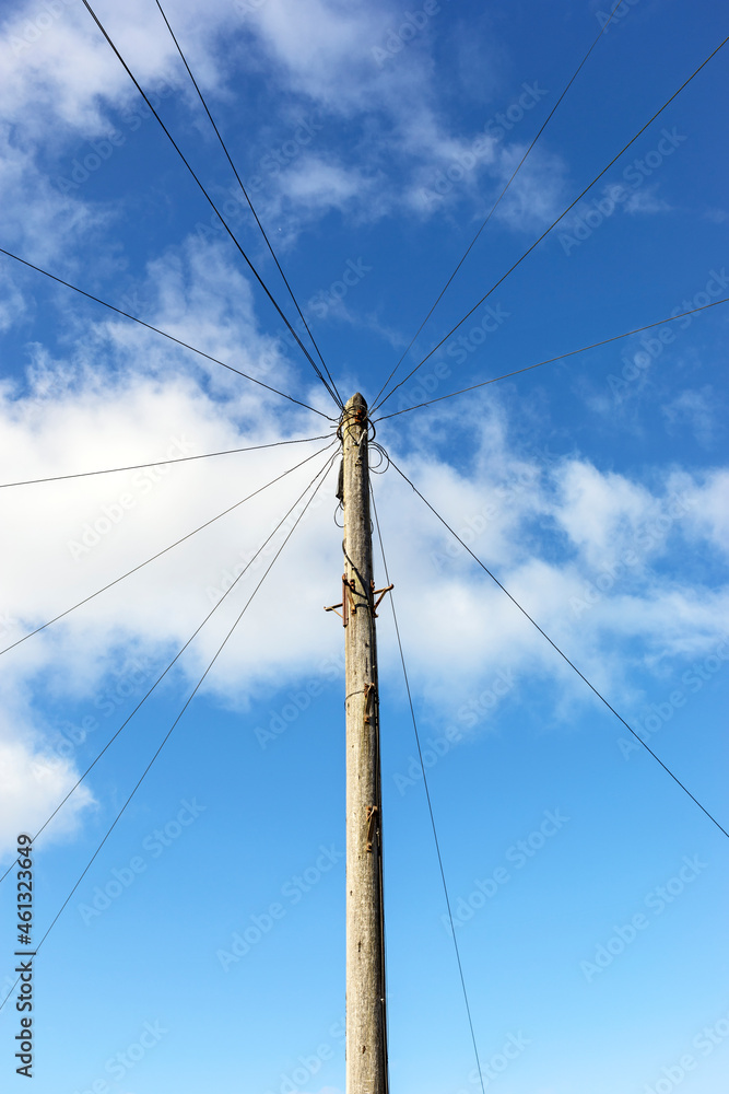 A telegraph pole carrying telephone cables to suburban houses in a town in the UK A telegraph pole carrying telephone cables to suburban houses in a town in the UK