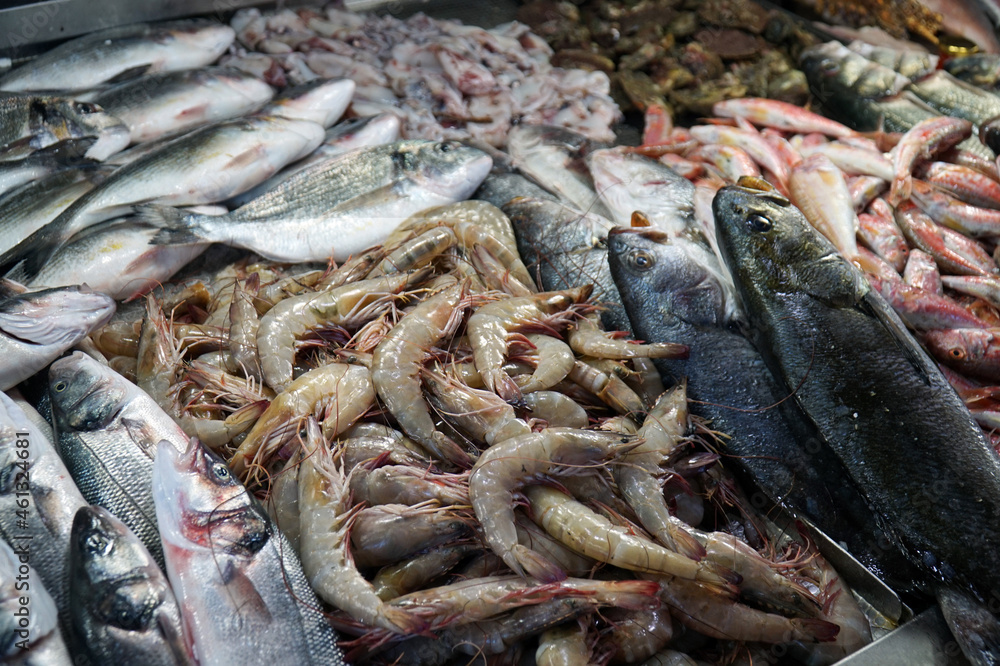 Fresh fish and seafood laid out on the counter for sale.      