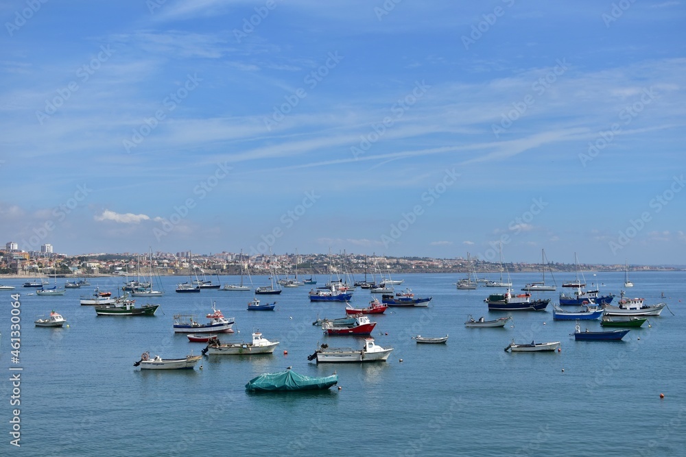 Boats in the harbor. Motor fishing boats in the bay on background of blue sky and sea town in haze