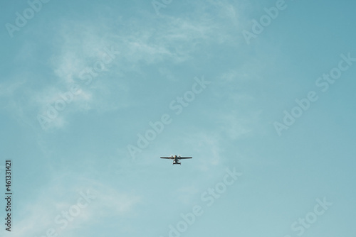 Silhouette of small plane flying in clear sky. Isolated airplane in the skies.