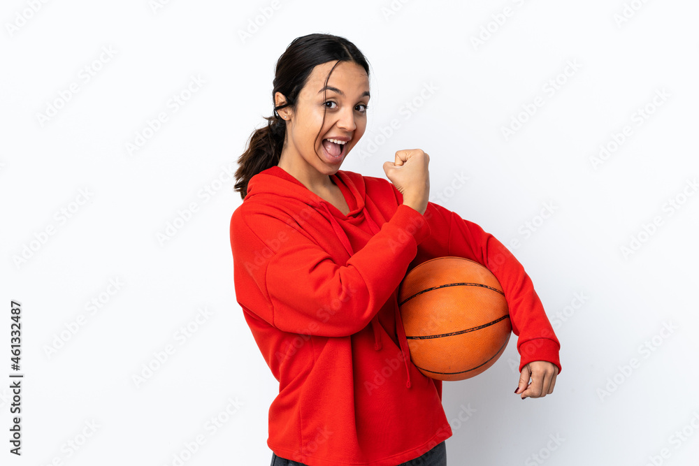 Young woman playing basketball over isolated white background celebrating a victory