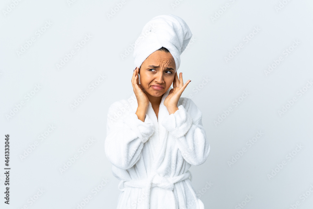 Young woman in bathrobe over isolated white background frustrated and covering ears Young woman in bathrobe over isolated white background frustrated and covering ears