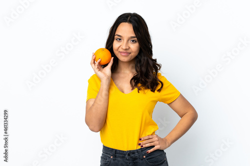 Young woman over isolated white background holding an orange