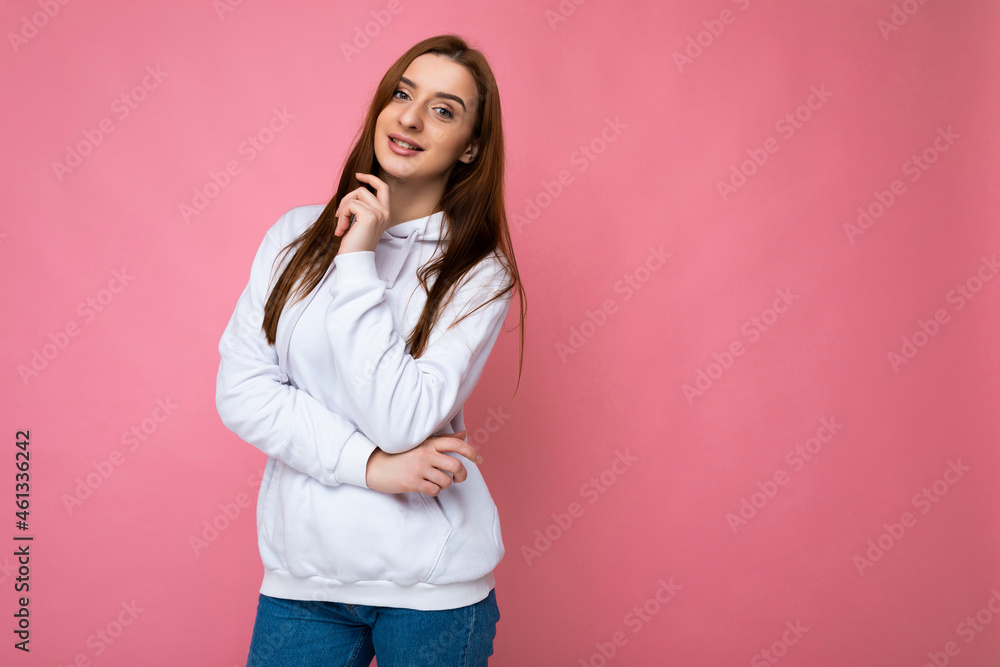 Smiling young beautiful brunette female person with sincere emotions isolated on background wall with copy space wearing casual stylish hoodie. Positive concept Smiling young beautiful brunette female person with sincere emotions isolated on background wall with copy space wearing casual stylish hoodie. Positive concept