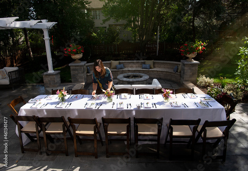 Woman setting up dinner table outdoor 