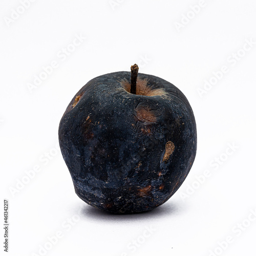 Blackened rotten apple isolated on white background. Object for design and project.