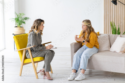 Teenage girl talks to school counselor. Child psychologist at work. photo