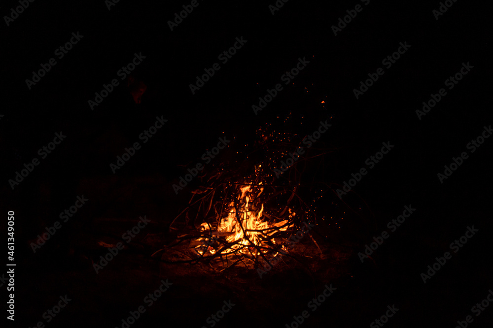 Campfire lit at night.