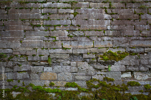 Old dark stone wall with moss as background. Wall cladding with masonry. Exterior panels. Flat lay.