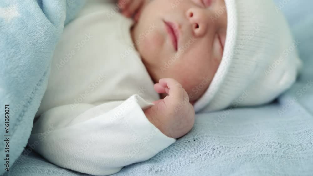 Close-up of Newborn Baby Face Portrait Early Days Sleeping Sweetly On White Blue Background. Child At Start Minutes Of Life on Hat. Infants, Childbirth, First Moments Of Borning, Beginning Concept Close-up of Newborn Baby Face Portrait Early Days Sleeping Sweetly On White Blue Background. Child At Start Minutes Of Life on Hat. Infants, Childbirth, First Moments Of Borning, Beginning Concept