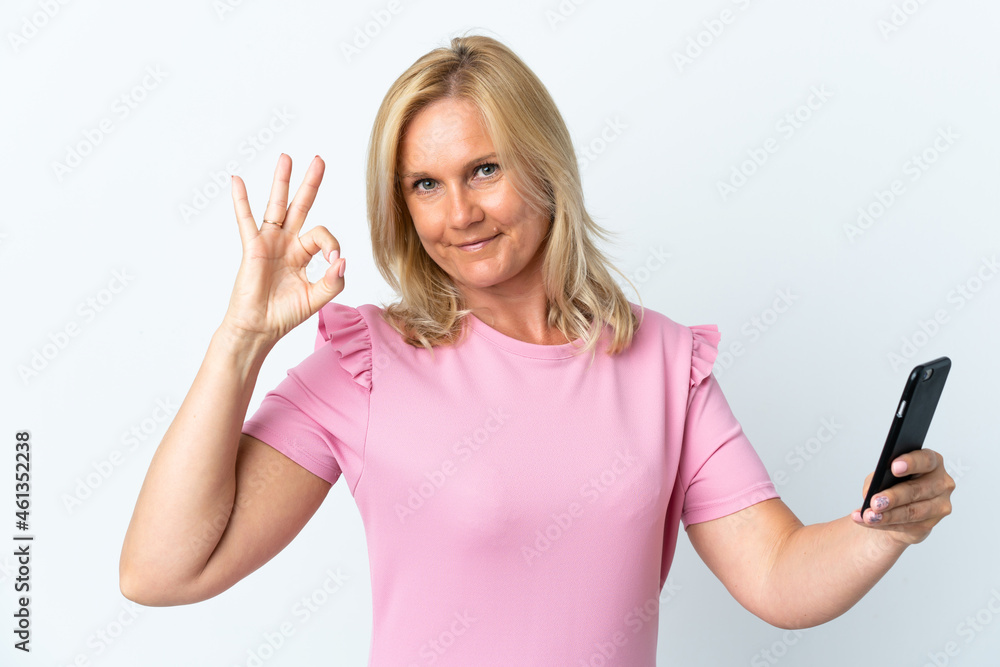 Middle age using mobile phone isolated on white background showing ok sign with fingers Middle age using mobile phone isolated on white background showing ok sign with fingers