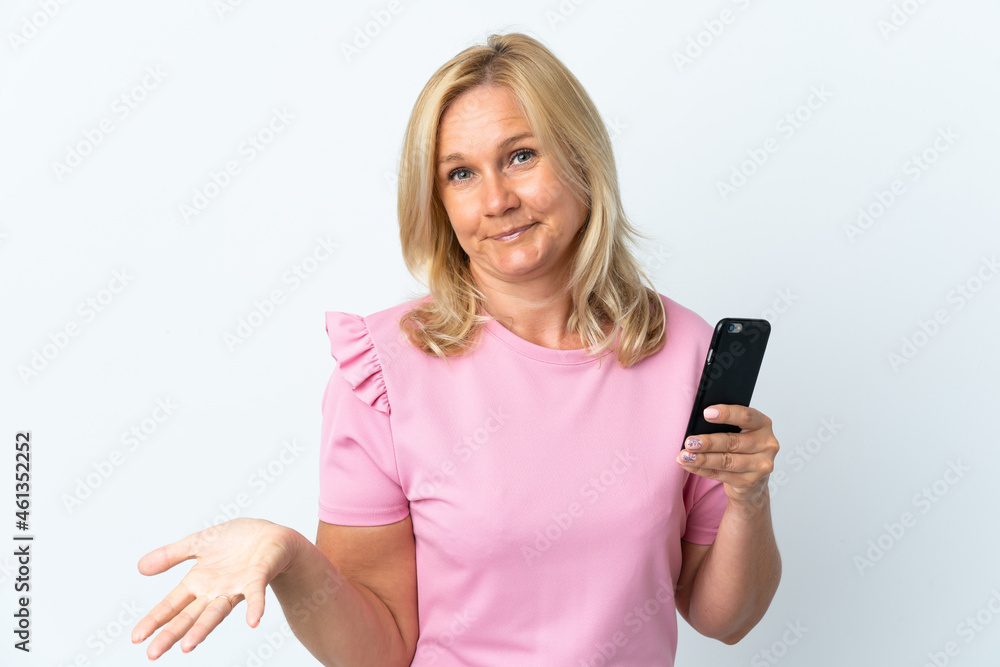 Middle age using mobile phone isolated on white background making doubts gesture while lifting the shoulders Middle age using mobile phone isolated on white background making doubts gesture while lifting the shoulders
