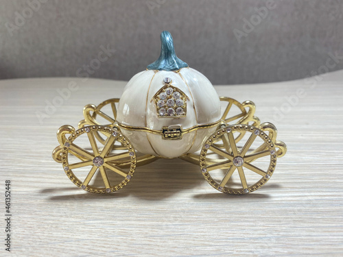 Statuette in the form of a pumpkin carriage on golden wheels close-up