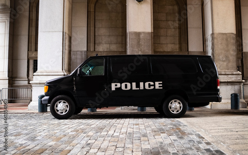 A black police van parked near New York City Hall and the Tweed Courthouse and Comptroller in Manhattan.  photo