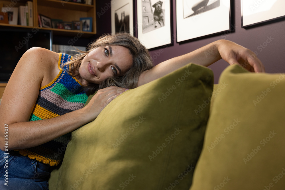 Portrait of casually dressed caucasian woman lounging on couch in home library Portrait of casually dressed caucasian woman lounging on couch in home library