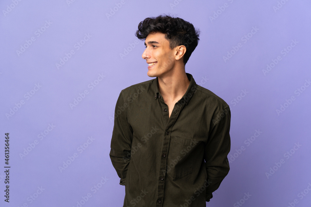 Young Argentinian man isolated on background looking side Young Argentinian man isolated on background looking side