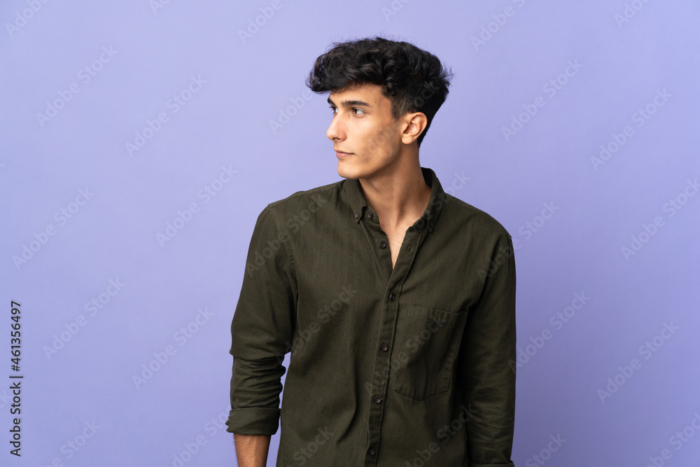 Obraz premium Young Argentinian man isolated on background looking to the side