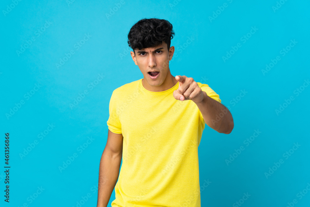 Young Argentinian man isolated on background frustrated and pointing to the front Young Argentinian man isolated on background frustrated and pointing to the front
