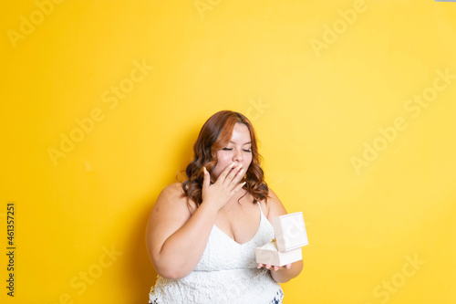 fat young model opening gift box with surprise face at christmas photo