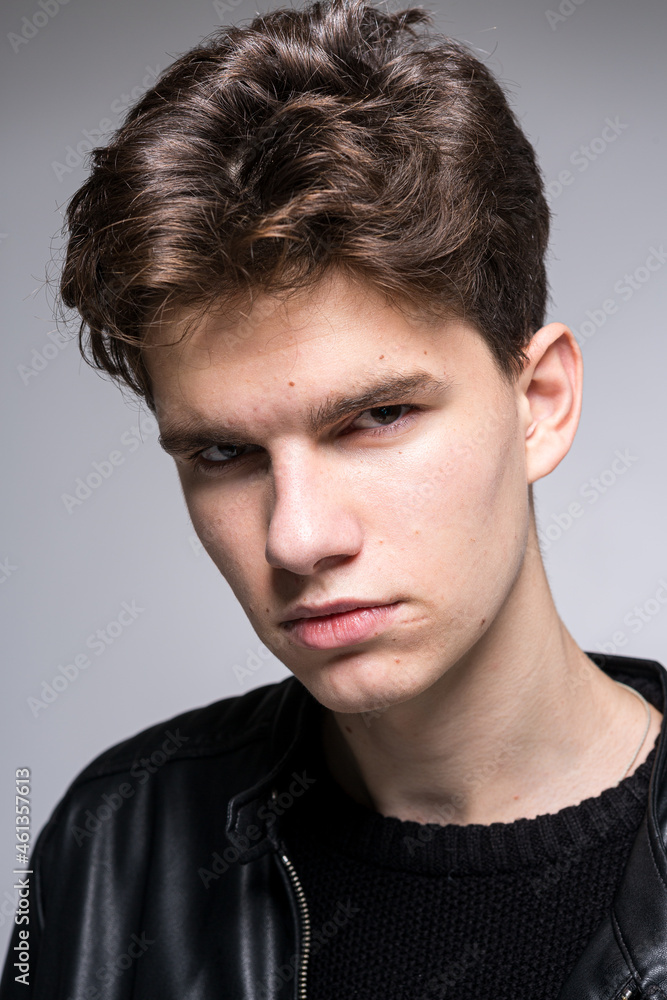 Obraz premium Wide angle portrait Young male model in black clothes posing in studio white background. Guy wearing black classic leather jacket. Handsome young fashion model man portrait. Attractive guy